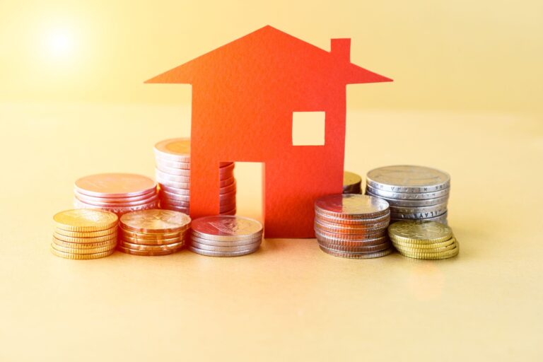 A paper house surrounded by coins in the concept of saving money when moving to Greenwich.