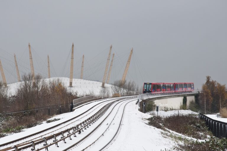 An incoming train on a snowy track in the concept of transport options in Greenwich.