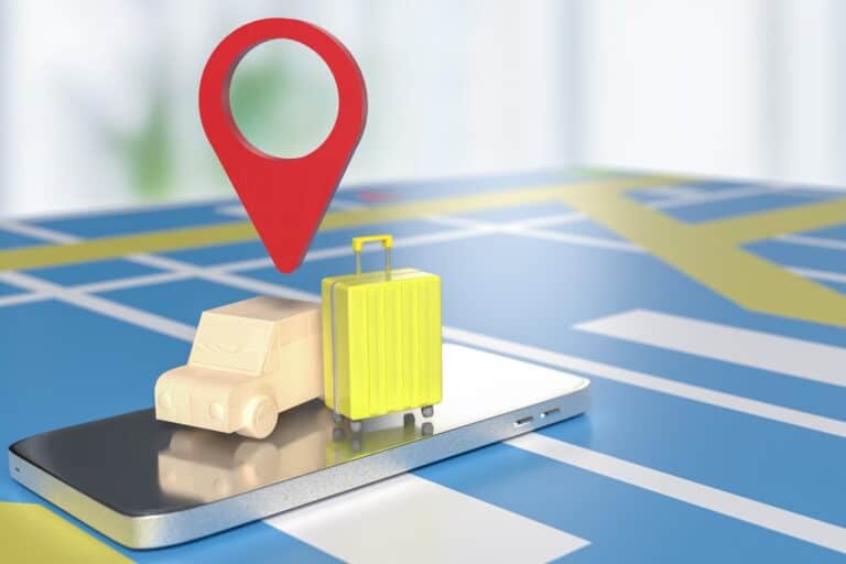 A 3D model of a van, suitcase, and pin locator on top of a cell phone and map in the concept of 'Can You Use a Man and Van Service for Long Distance Moves When Relocating to Greenwich?'